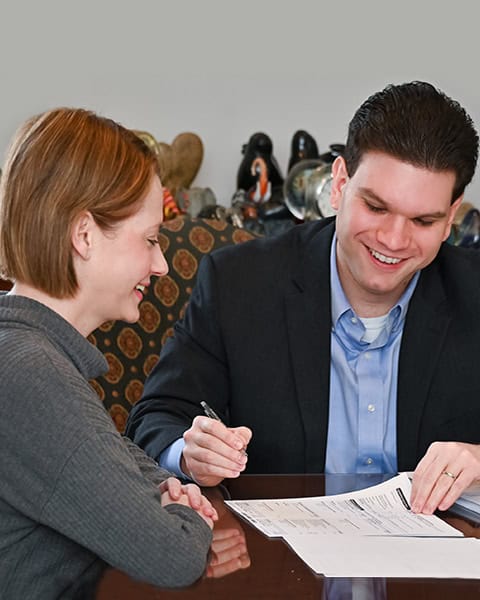 Attorney and client at desk with papers, consulting on real estate matter.