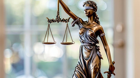 Statue of blind-folded woman holding scales of justice.